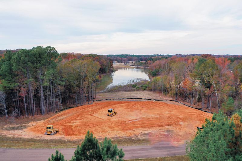 CAT excavator pulling trees on a land clearing project